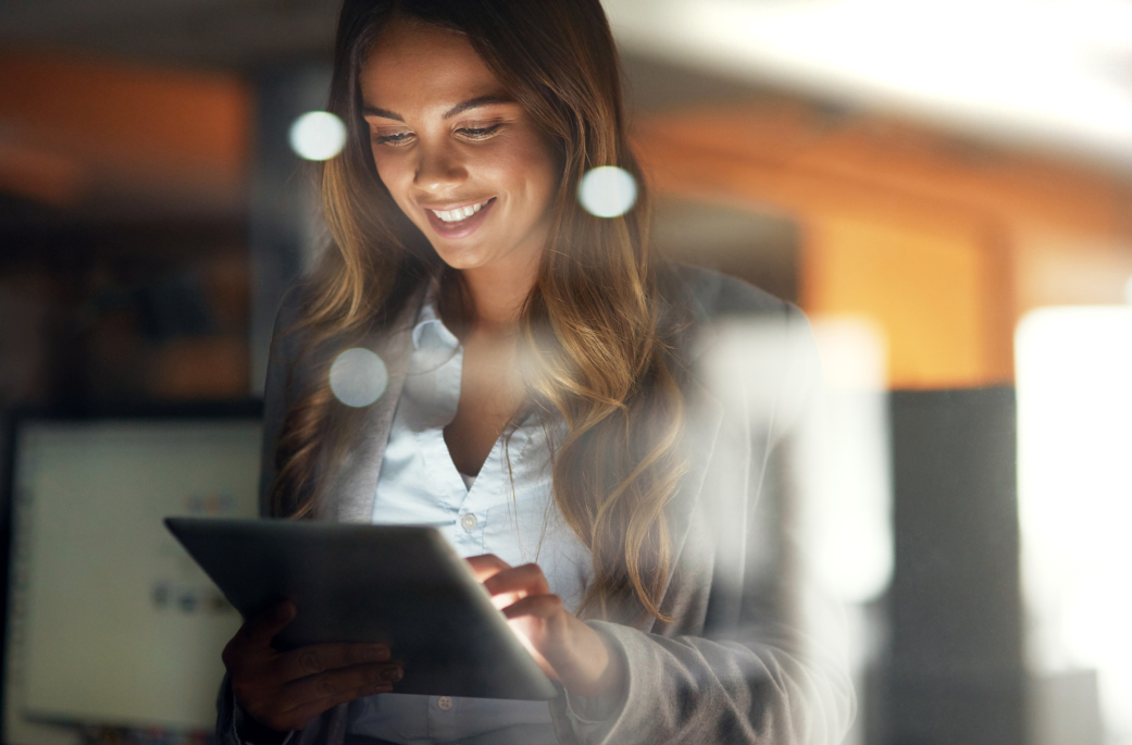 Smiling woman at an office working on a tablet 