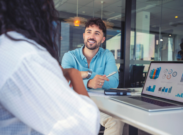 Man in blue shirt at office talking with a colleague